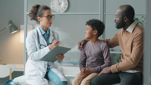 Female Pediatrician Giving Consultation to African American Boy and His Dad