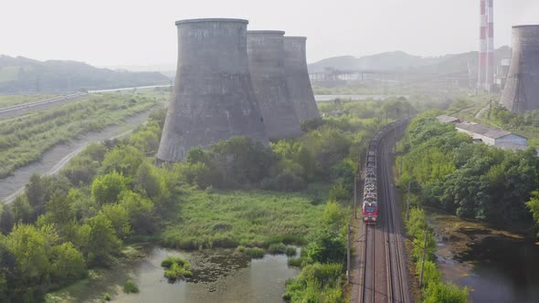 Drone View of a Moving Train and Cooling Towers