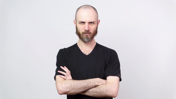 Strict man raising finger in warning gesture over white background.