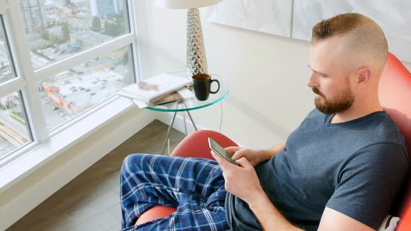 Man using mobile phone in living room 4k