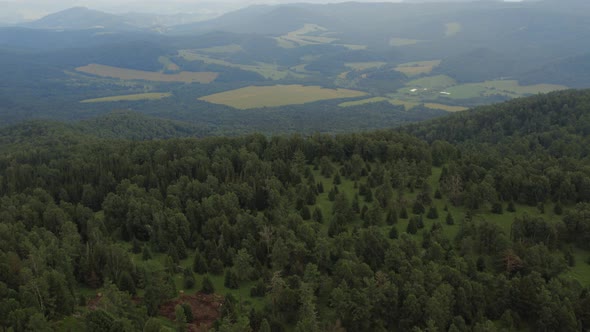 Green forest and valley on mountains of Manzherok under blue sky