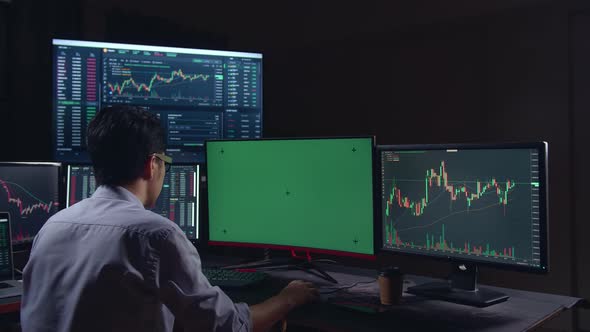 Stock Market Trader Working On A Computer With Isolated Mock-Up Green Screen And Analyzing Graphs