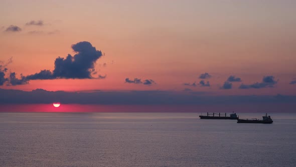 Romantic colorful sunset at the sea. Against the background of the sea, the sun goes down alt