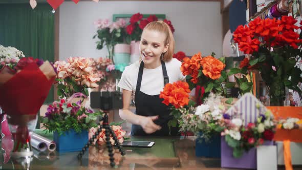 Female Florist Discusses the Order By Talking on Video Call Using a Smartphone and Screen Tablet in