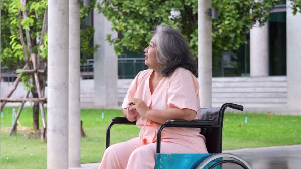 Happy old elderly Asian woman uses a wheelchair in the hospital after recovering from an accident. C