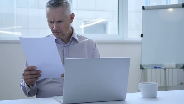 Penisve Man Reading Papers