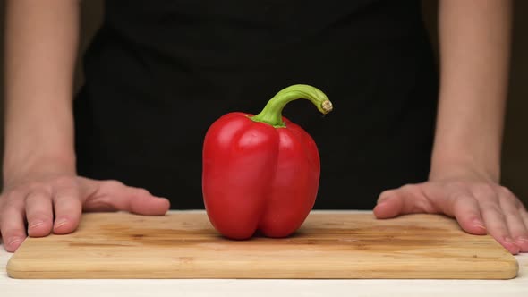 woman sweeps meat and sausages from the board, then puts the sweet red pepper