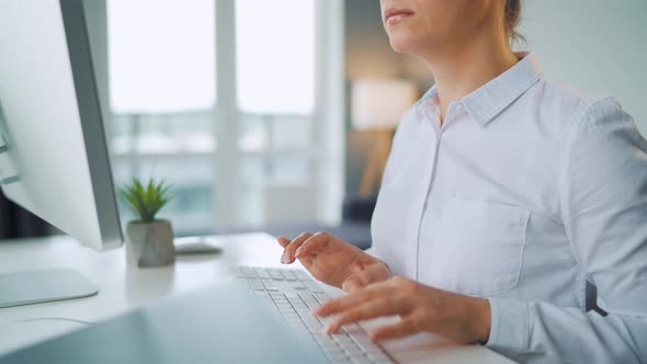 Woman with Glasses Typing on a Computer Keyboard. Concept of Remote Work.