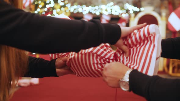 Close Up of Young Girls Hands Making Knot on Big Candy Gift Box of Candy Among