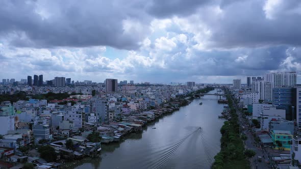 Aerial view along an urban canal in Saigon or Ho Chi Minh City, Vietnam with dramatic sky and boats