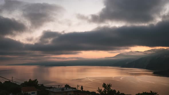 Dramatic and Moody Time Lapse Shot of Sunrise Over Rocky Shore and Calm Sea on Kefalonia Island