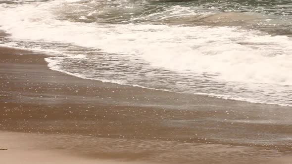 Waves lapping on shallow beach shoreline.