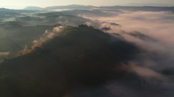 4K Scenic flight over beautiful mountain scape with bright sky and clouds