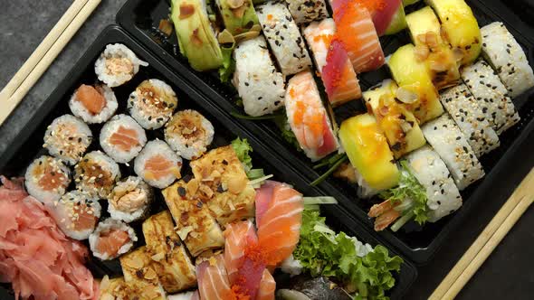 Close Up of Various Sushi Set in Black Plastic Delivery Box