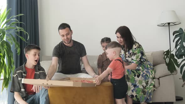 Family Eating Pizza Sitting on Sofa at Home