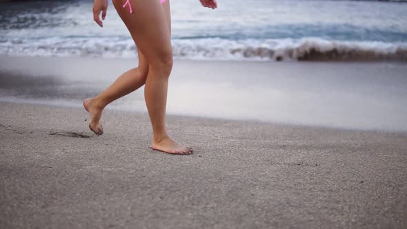Female Sporty Legs Tourist Walking Barefoot on Shore at Sunset