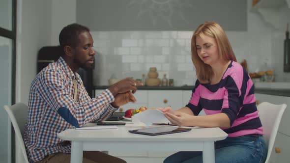 Stressed Multiethnic Couple Reviewing Bank Invoices