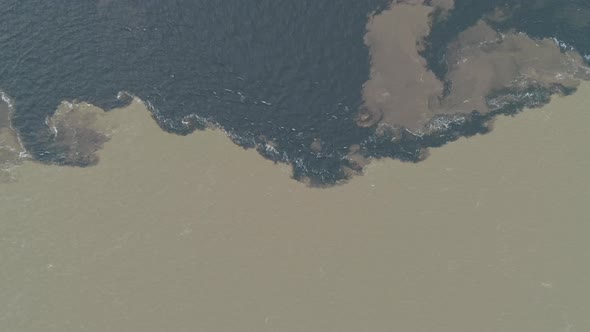 Water from Negro River and Solimoes River meeting in the Amazon, aerial shot, mixing, texture