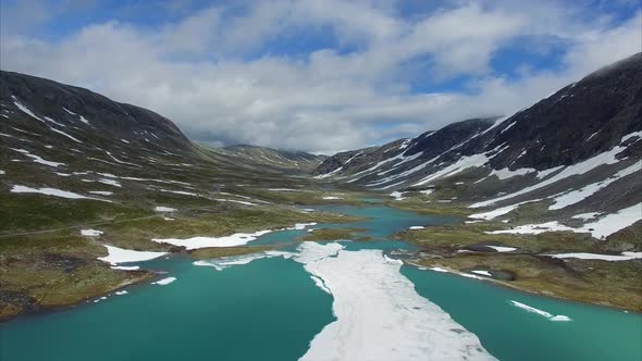 Flight above frozen lake in mountain pass in Norway