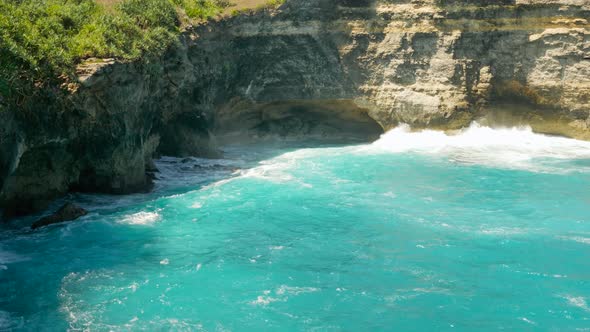 View on Waves Break on Rock Cliff