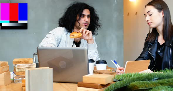 Executive discussing over laptop while having breakfast