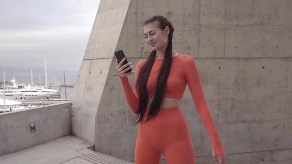 Caucasian Young Woman Using Smart Phone While Exercising