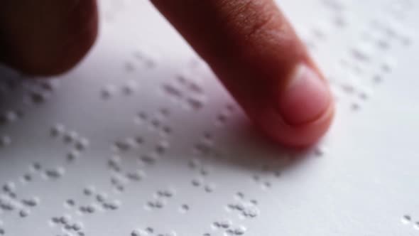 School Kid Reading a Braille Book in Classroom at School