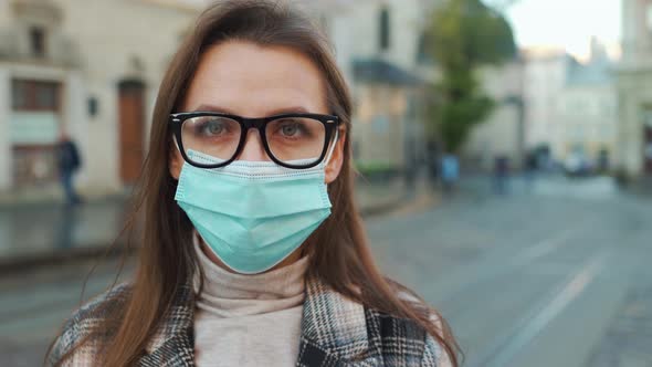 Pandemic Protection of the Covid-19 Coronavirus. Portrait of a Woman in a Coat, Glasses and a