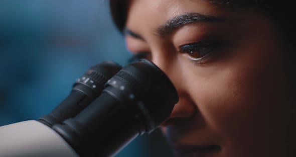 Close Up of a Female Research Scientist Eyes,looking at Samples Under Microscope