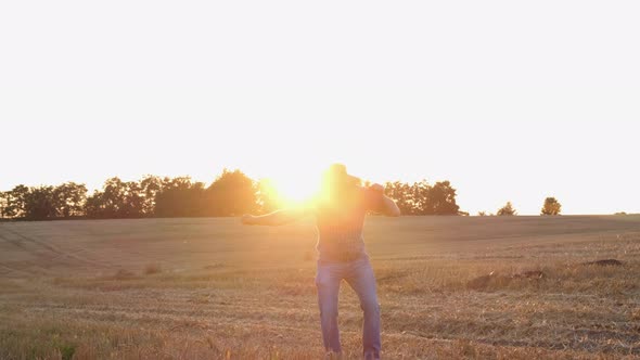 Silhouette of a Farmer Having Fun and Dancing in the Field