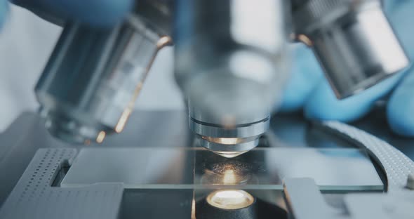 Close Up Shot of the Scientist Studies Examining of Test Sample Under the Microscope.