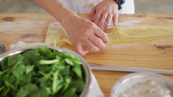 Caucasian female chef teaching diverse group preparing dishes and smiling