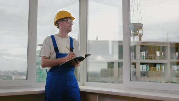 Construction Worker Writing a Check List or Taking Notes alt
