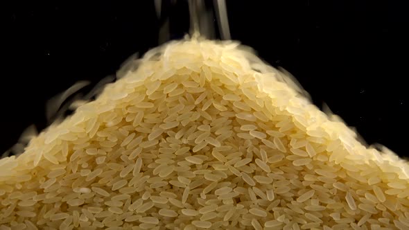 Pouring rice on a black background. 