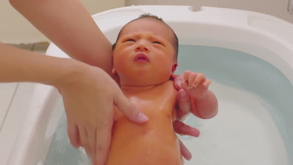 Calm of asian newborn baby bathing in bathtub