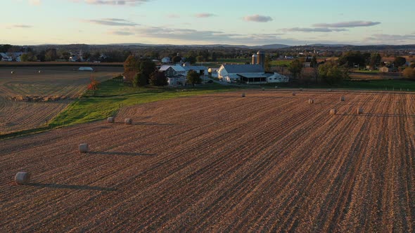 Reversal drone shot over pastures and a farmhouse that reveals a vast farmland