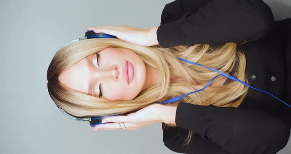 Beautiful 30 Year Old Woman Puts on Her Headphones and Nods to the Quiet Music