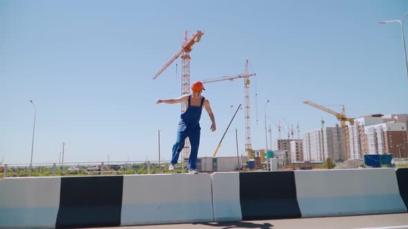 Happy Caucasian Man Builder in Hard Hat Dancing. Worker Funny Moves Background Construction Site.