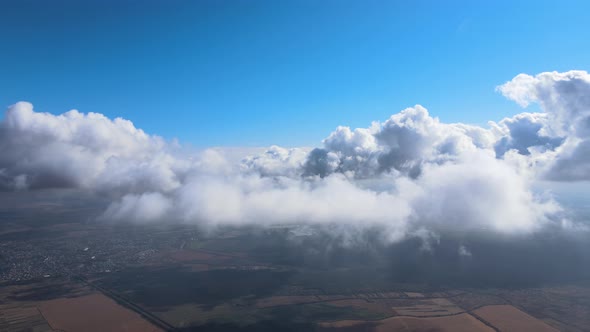 Aerial View From Airplane Window at High Altitude of Earth Covered with White Puffy Cumulus Clouds