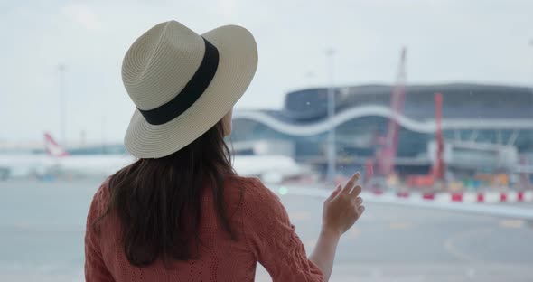 Woman look at the plane in the airport 