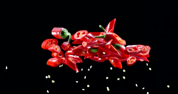 Red chili peppers slowly fly up and fall on a black background. Blackmagic Ursa Pro G2, 300 fps.