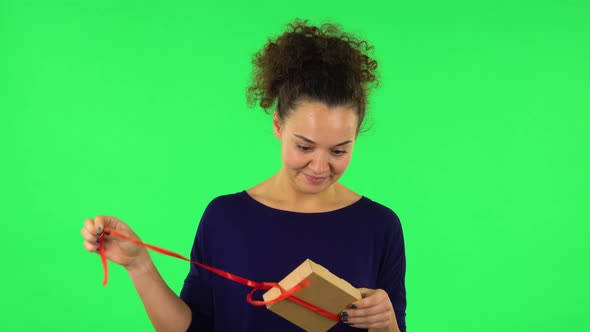 Portrait of Curly Woman Opening the Gift, Very Surprised and Rejoicing . Green Screen