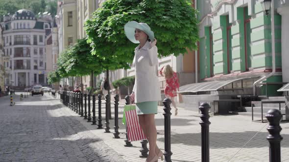 Wide Shot Portrait of Elegant Woman Crossing the Street. Beautiful Mid-adult Caucasian Lady Walking