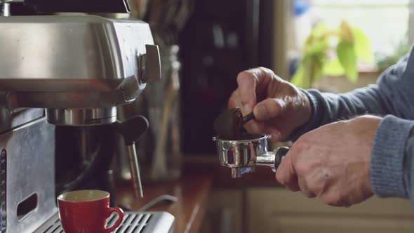 Senior man making coffee at home