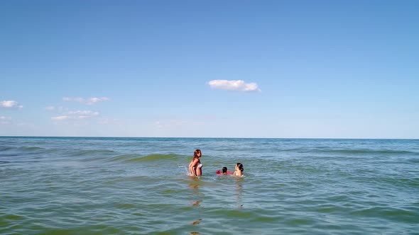 Green Sea in Which Mom and Daughters Swim