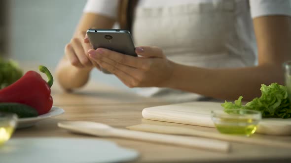 Close-Up of Female Hands Scrolling on Smartphone, Woman Choosing Salad Recipe