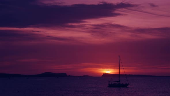 Sea Sunset behind the Mountain Islands with Sailing Ship and Bird Flying by 