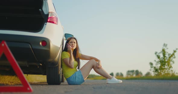 Upset Girl Sits Nearbroken Car on Side of Road and Calls for Help on Phone