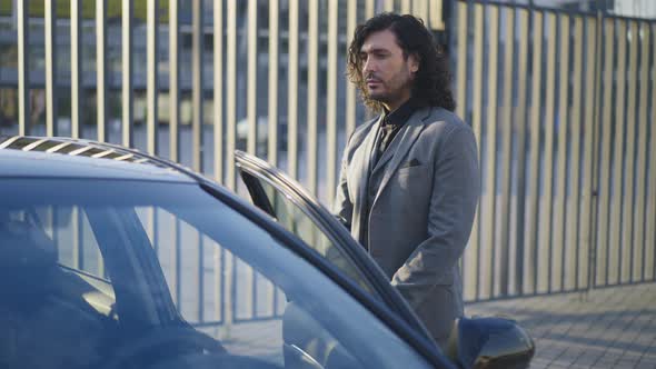 Serious Confident Businessman Opening Car Door Sitting Down on Driver's Seat in Slow Motion