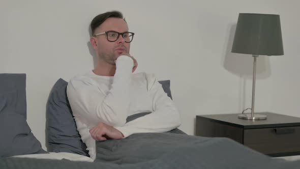 Pensive Casual Man Thinking While Sitting in Bed